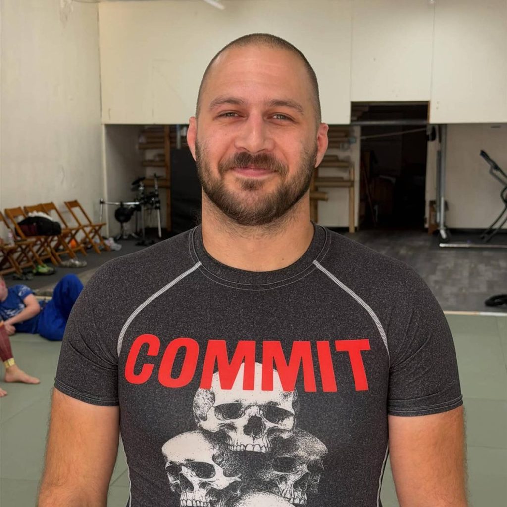 Head coach Jacob Propst smiling on the mats at Consecution Jiu-Jitsu