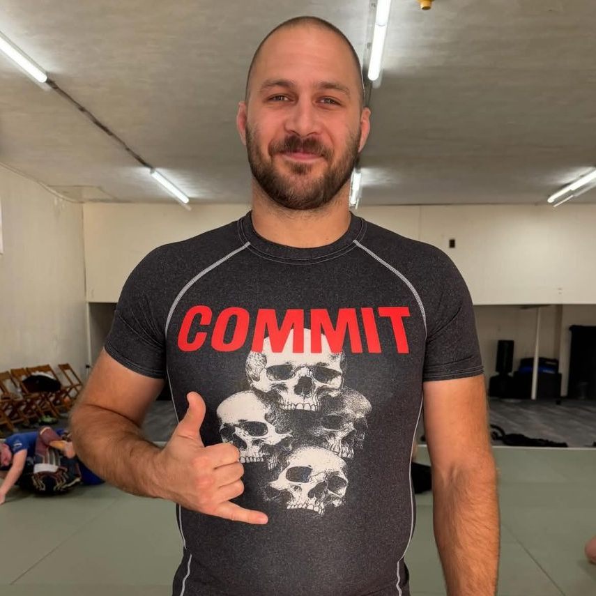 Coach Jacob Propst throwing a shaka on the mats